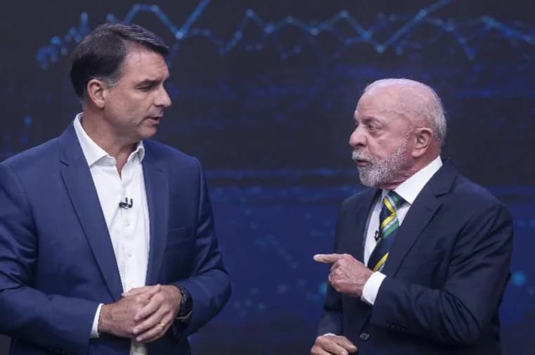Flávio Bolsonaro e Lula conversam no palco do debate