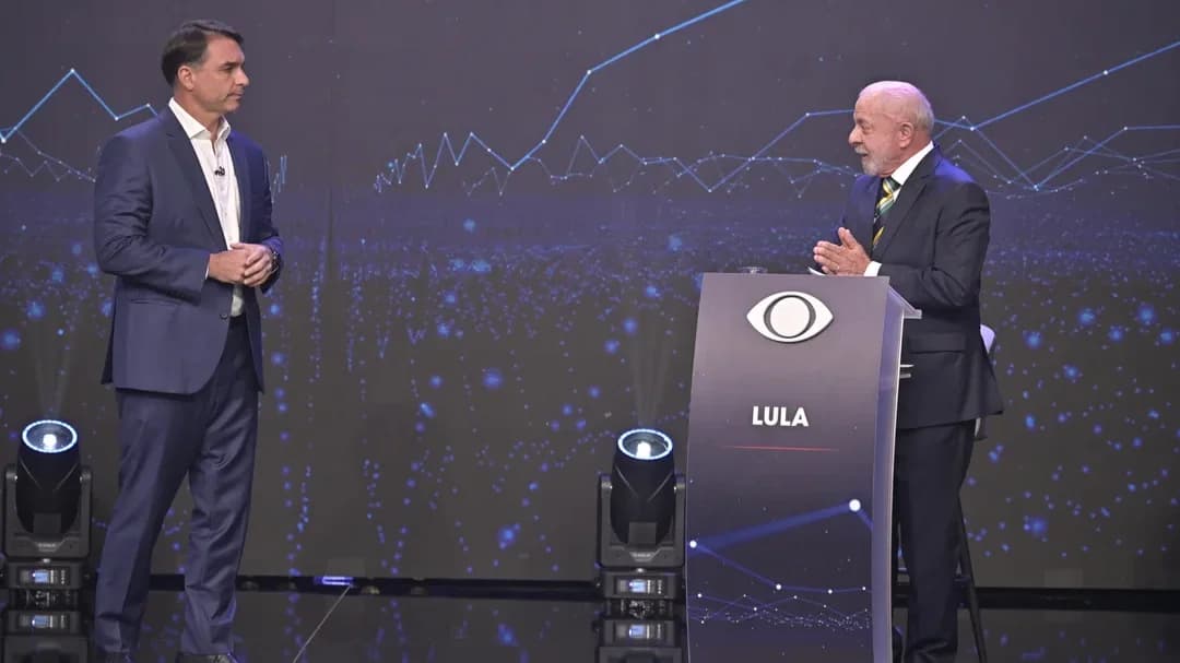Flávio Bolsonaro e Lula no palco do debate da Band