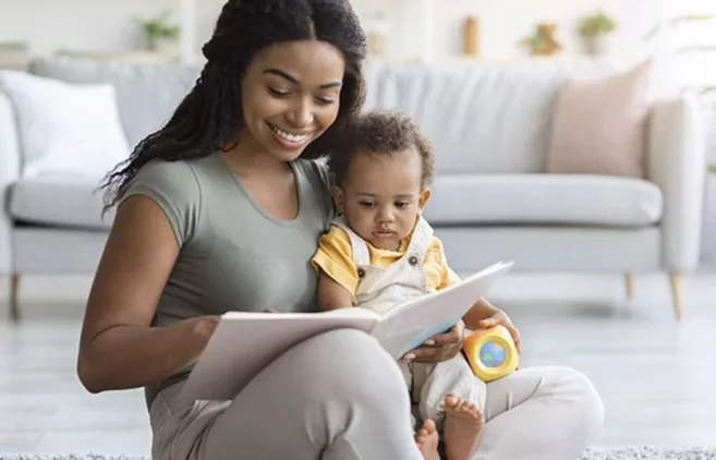 Mãe lê um livro com o filho pequeno no colo