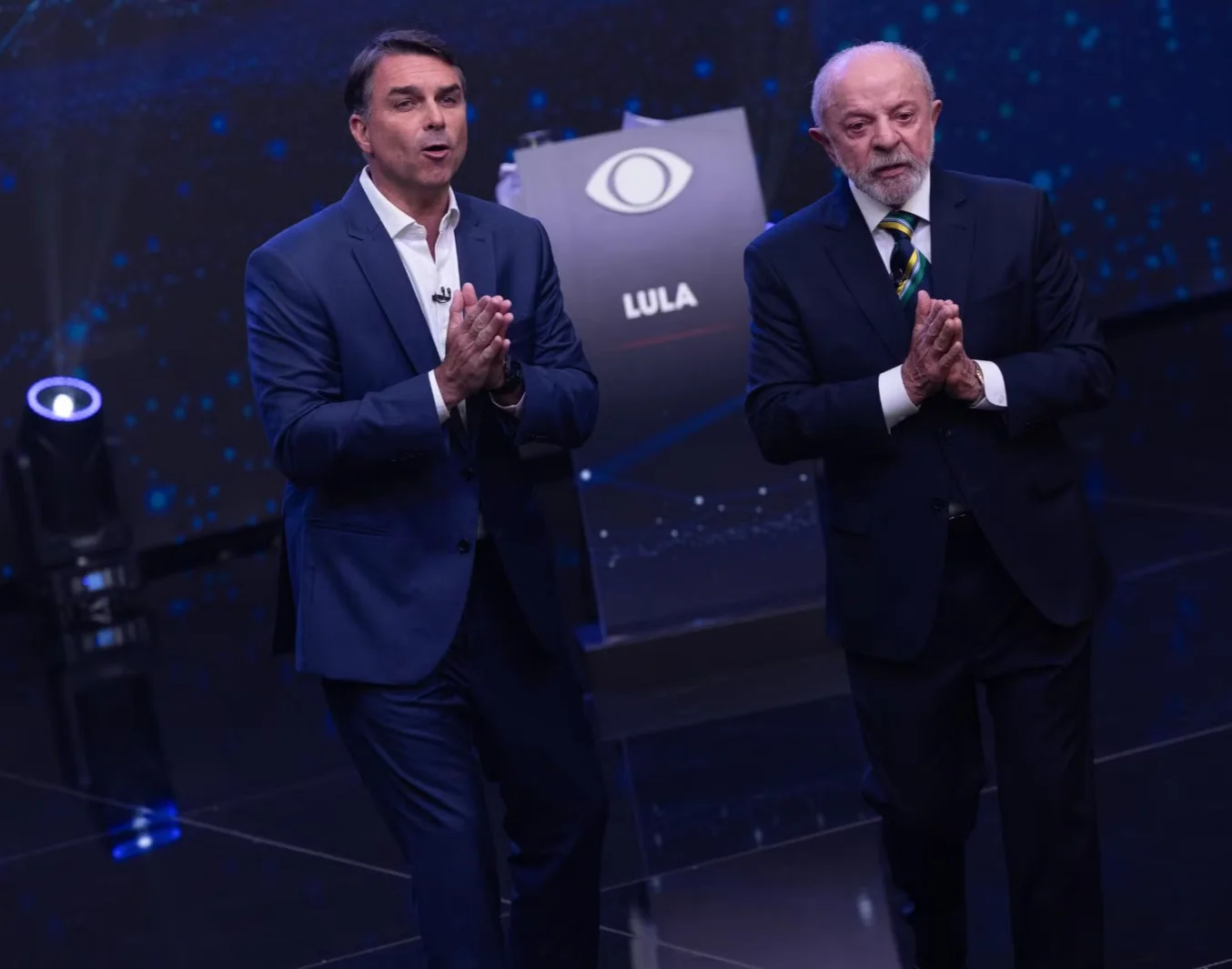 Flávio Bolsonaro e Lula no palco do debate da Band