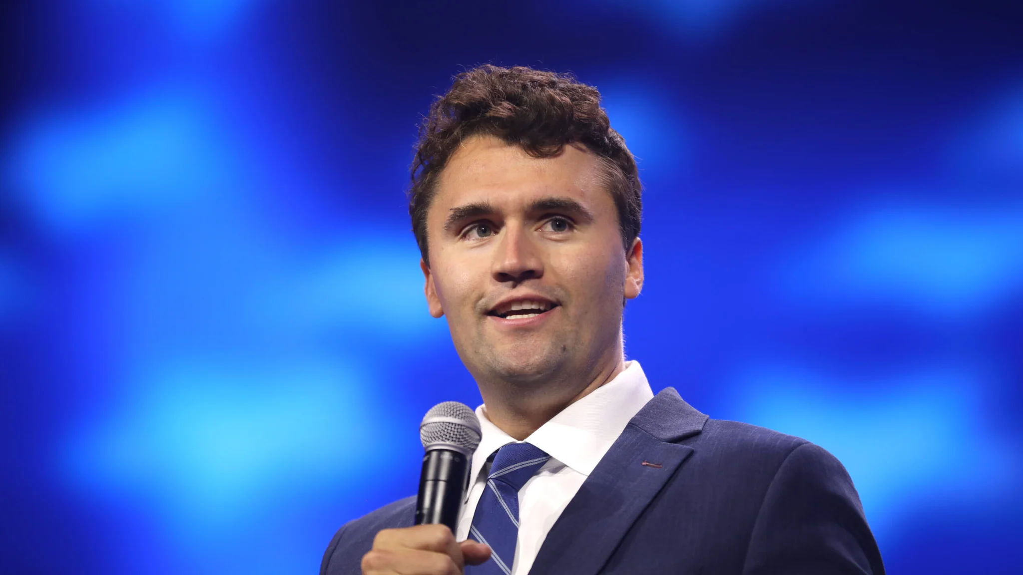 O ativista Charlie Kirk discursa com microfone na mão