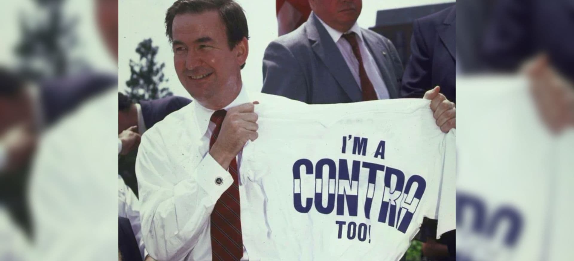 Ronald Reagan segurando uma camiseta com a frase "I'm a contra too"