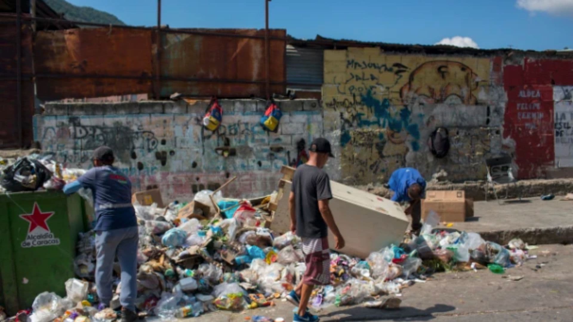 Pessoas procuram itens para venda e alimentação em uma lixeira na favela de Antimano, em Caracas.