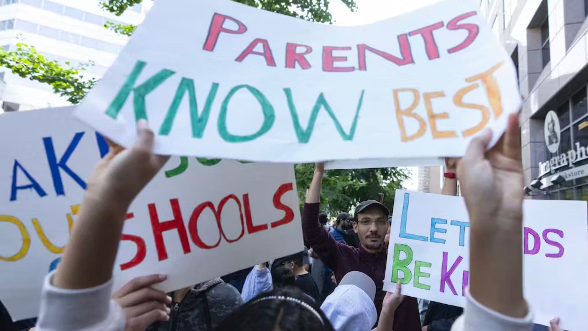 Manifestantes com cartazes no Canadá contra os programas de identidade de gênero nas escolas.