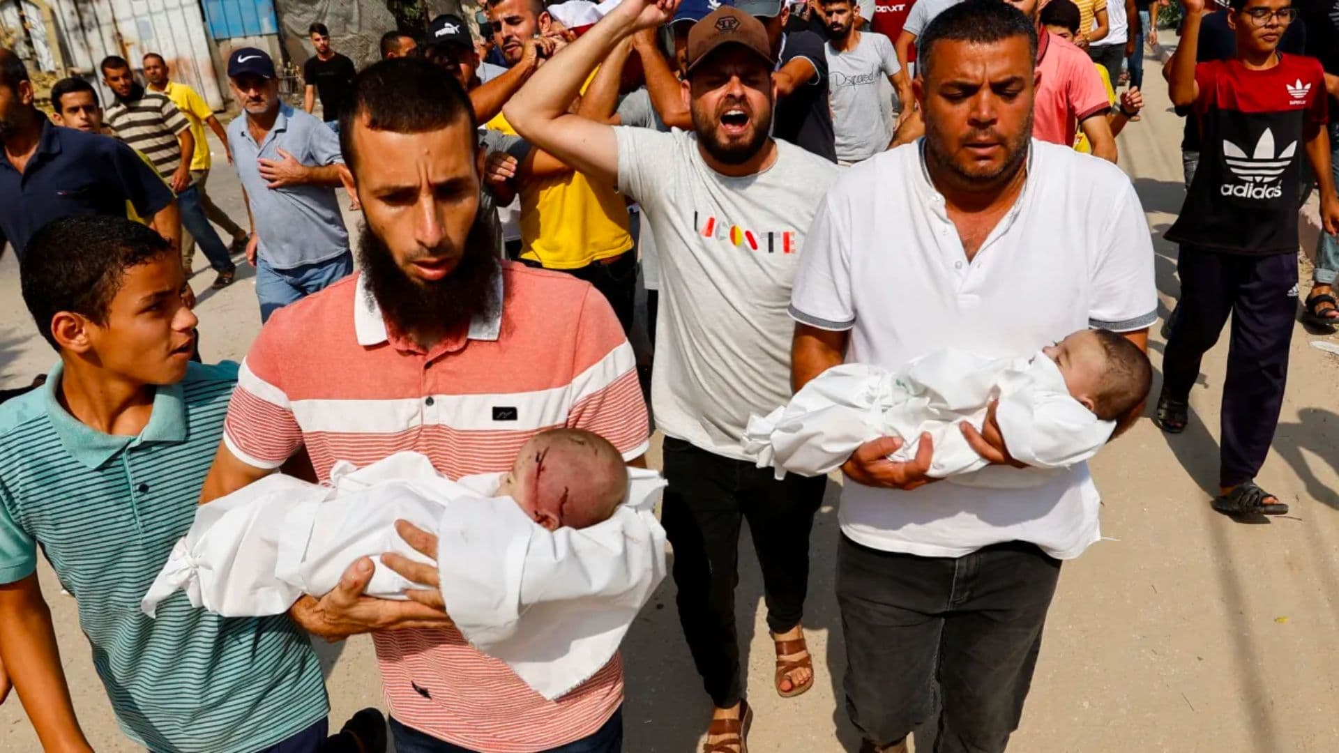 Palestinos carregam corpos de bebês gêmeos mortos em ataques de Israel junto com suas três irmãs e sua mãe, segundo relatos de autoridades de saúde