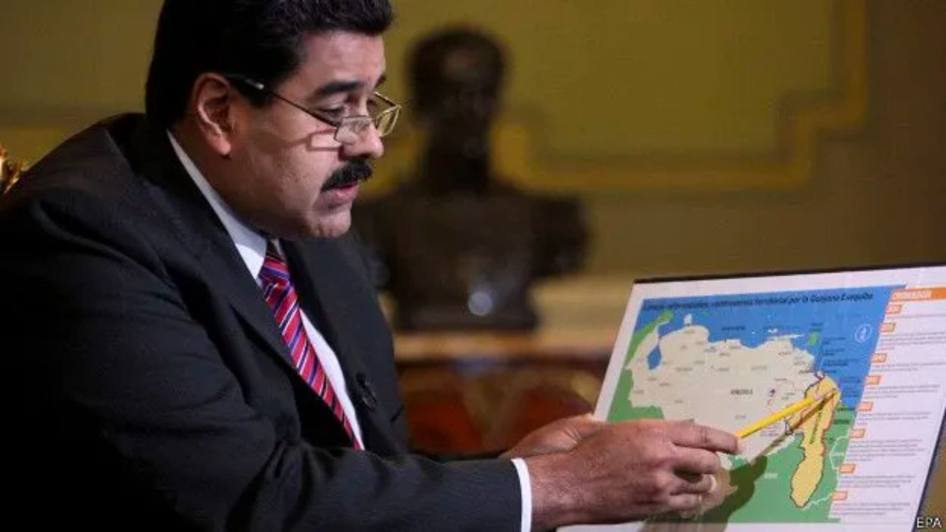 O presidente venezuelano Nicolás Maduro aponta para a região de Esequibo, alvo de disputa com a Guiana, em um mapa.