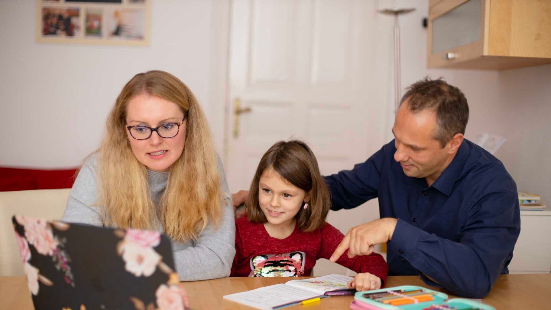 Pais praticando homeschooling com filha.