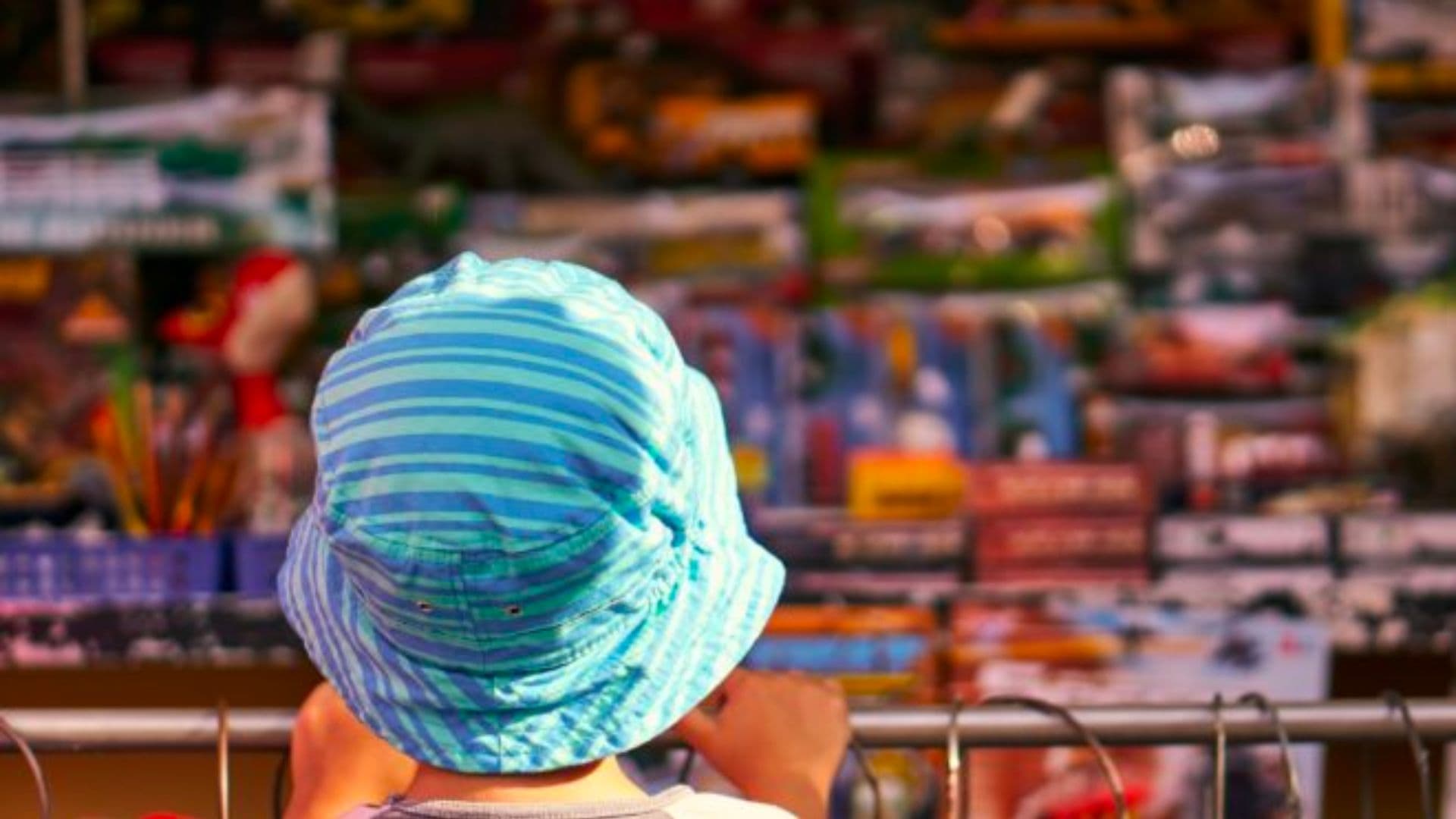 Criança observando brinquedos em loja.