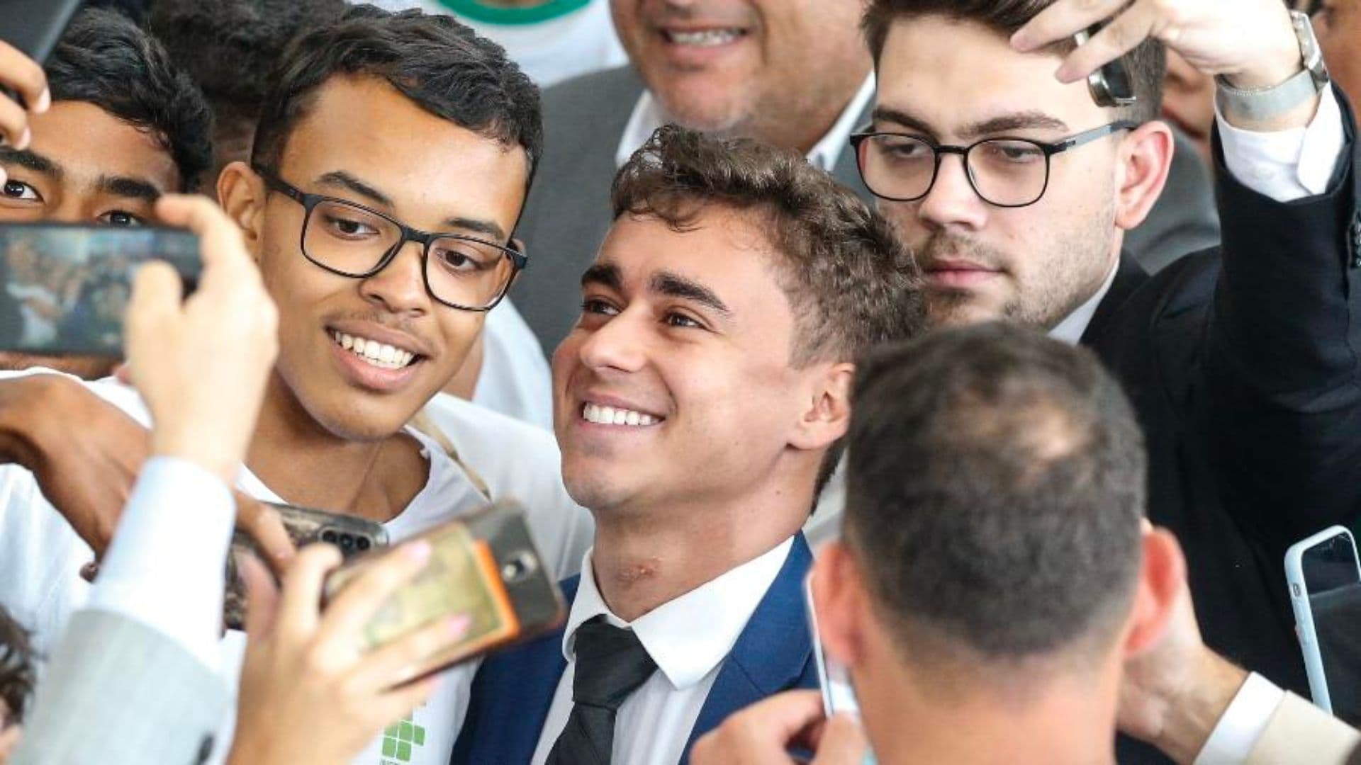 O deputado Nikolas Ferreira posa com estudantes em cerimônia no Palácio do Planalto