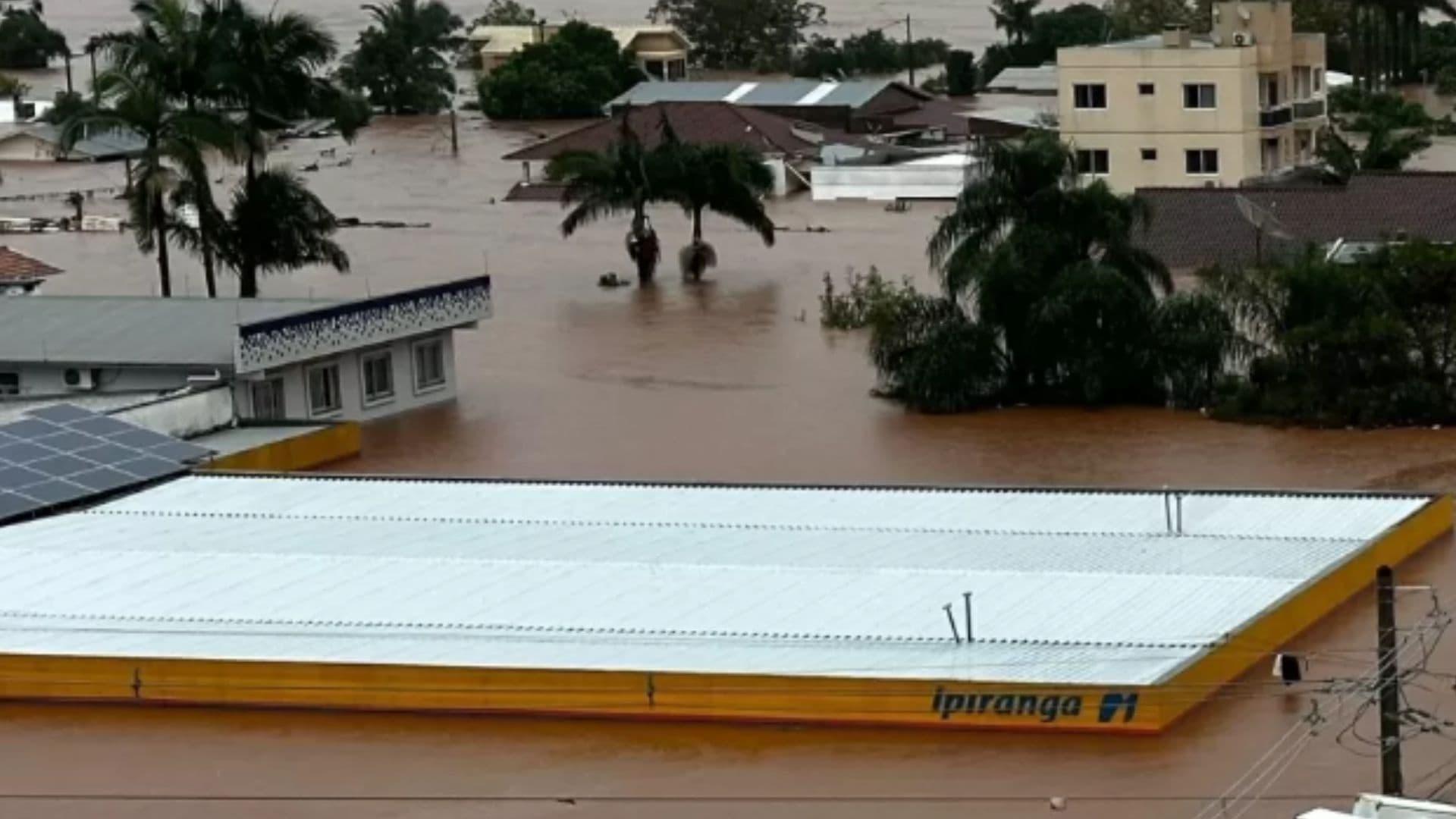 Imagem de cidade do Rio Grande do Sul inundada. Apenas o teto de um posto de gasolina aparece