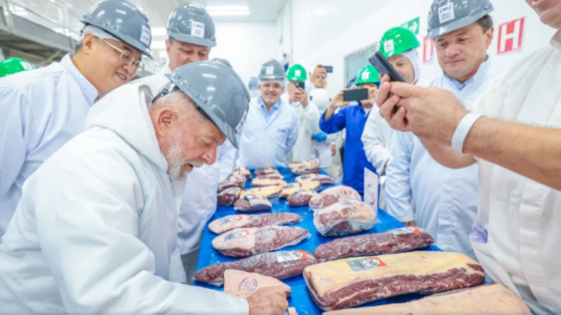 Lula aparece observando carnes na esteira de uma fábrica