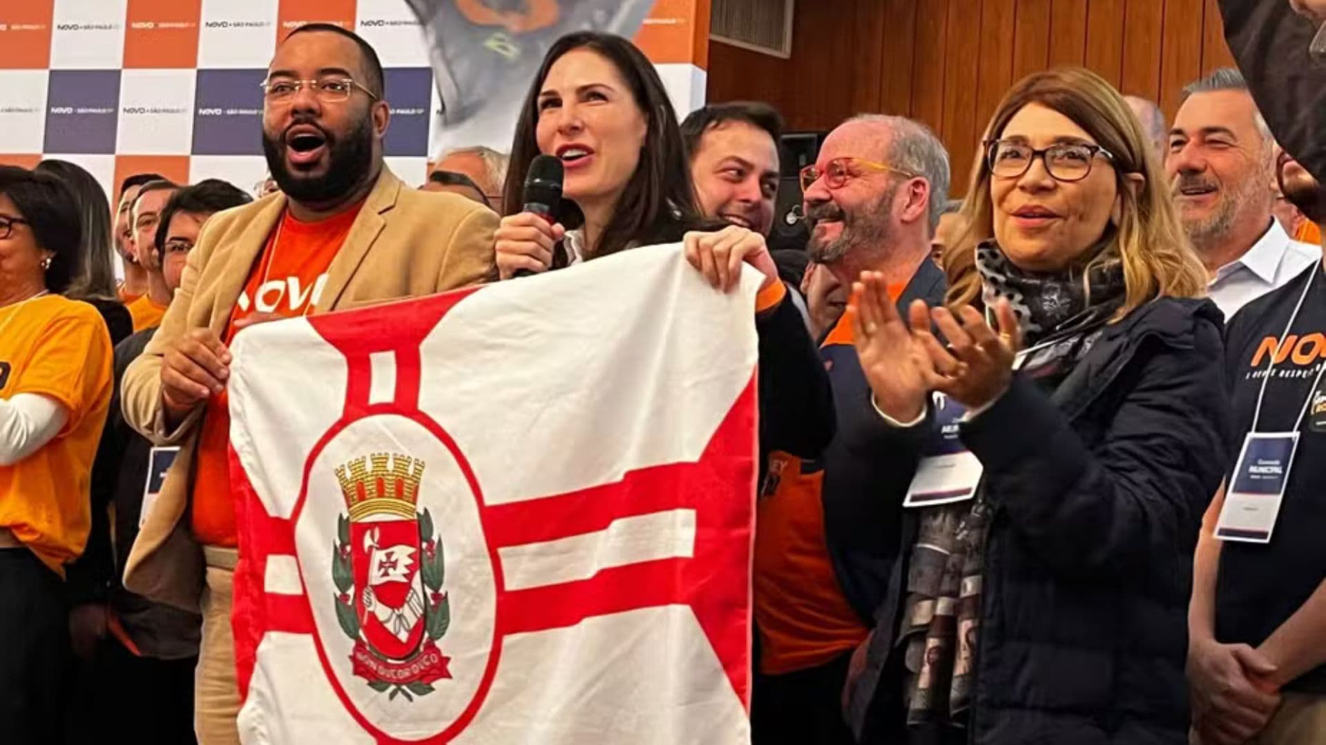 Candidata do Partido Novo, Maria Helena, segurando a bandeira da cidade de São Paulo.