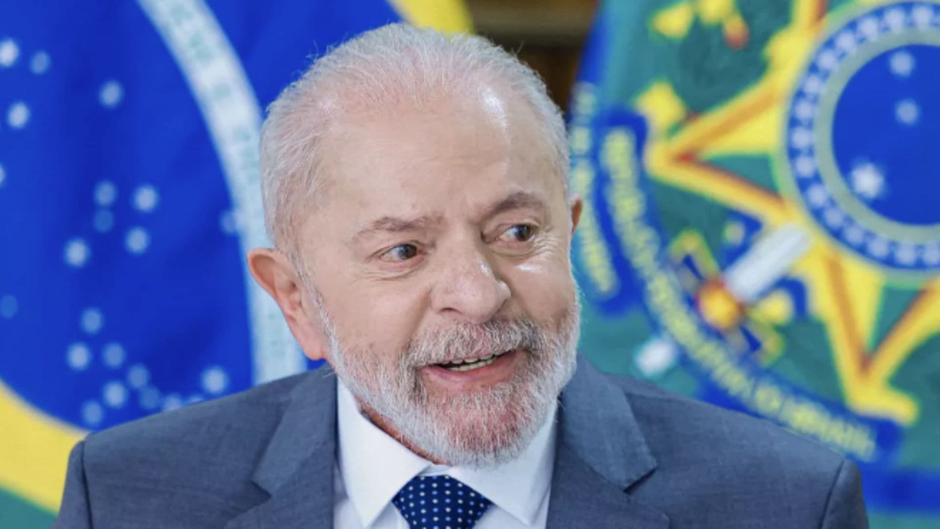 Lula aparece em frente à bandeira do Brasil