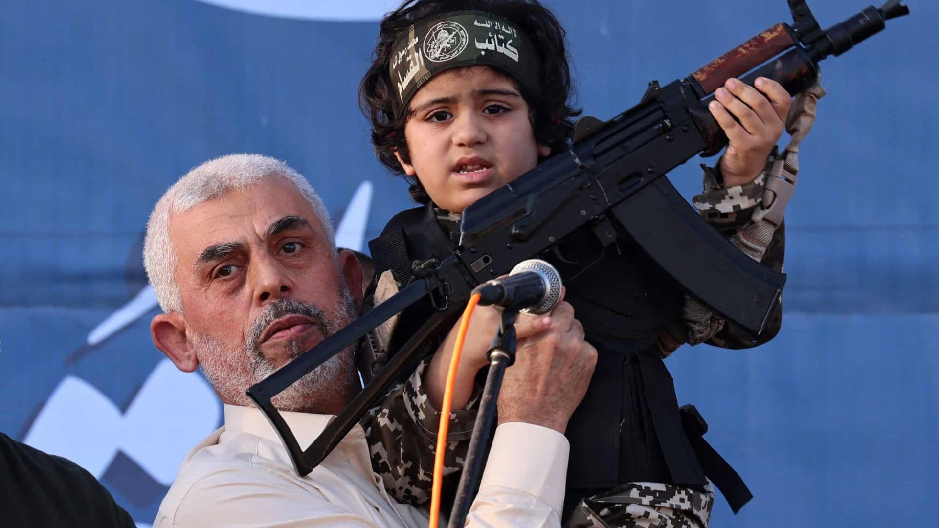 Novo líder do Hamas, Yahya Sinwar, levantando uma criança que segura um fuzil da plataforma AK em suas mãos.