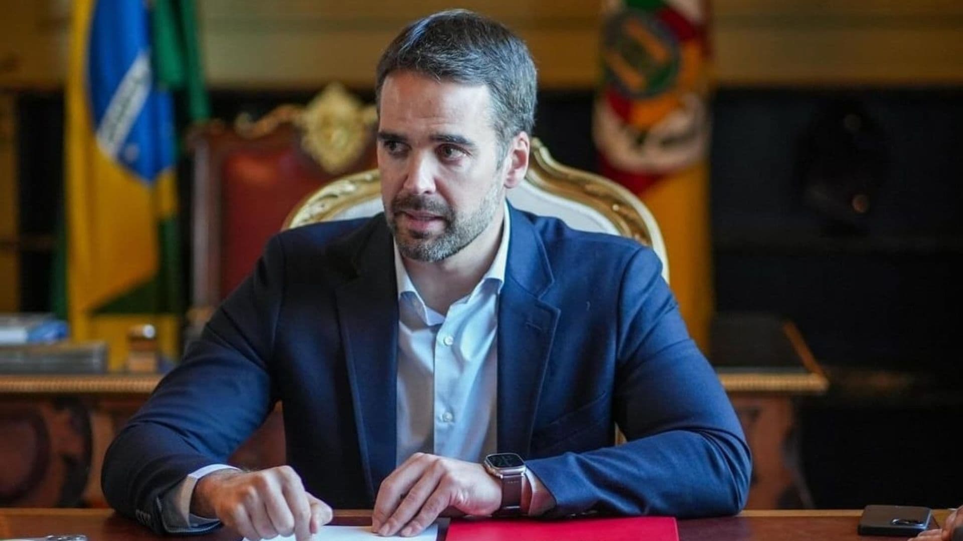 Leite aparece sentado em uma mesa de reunião