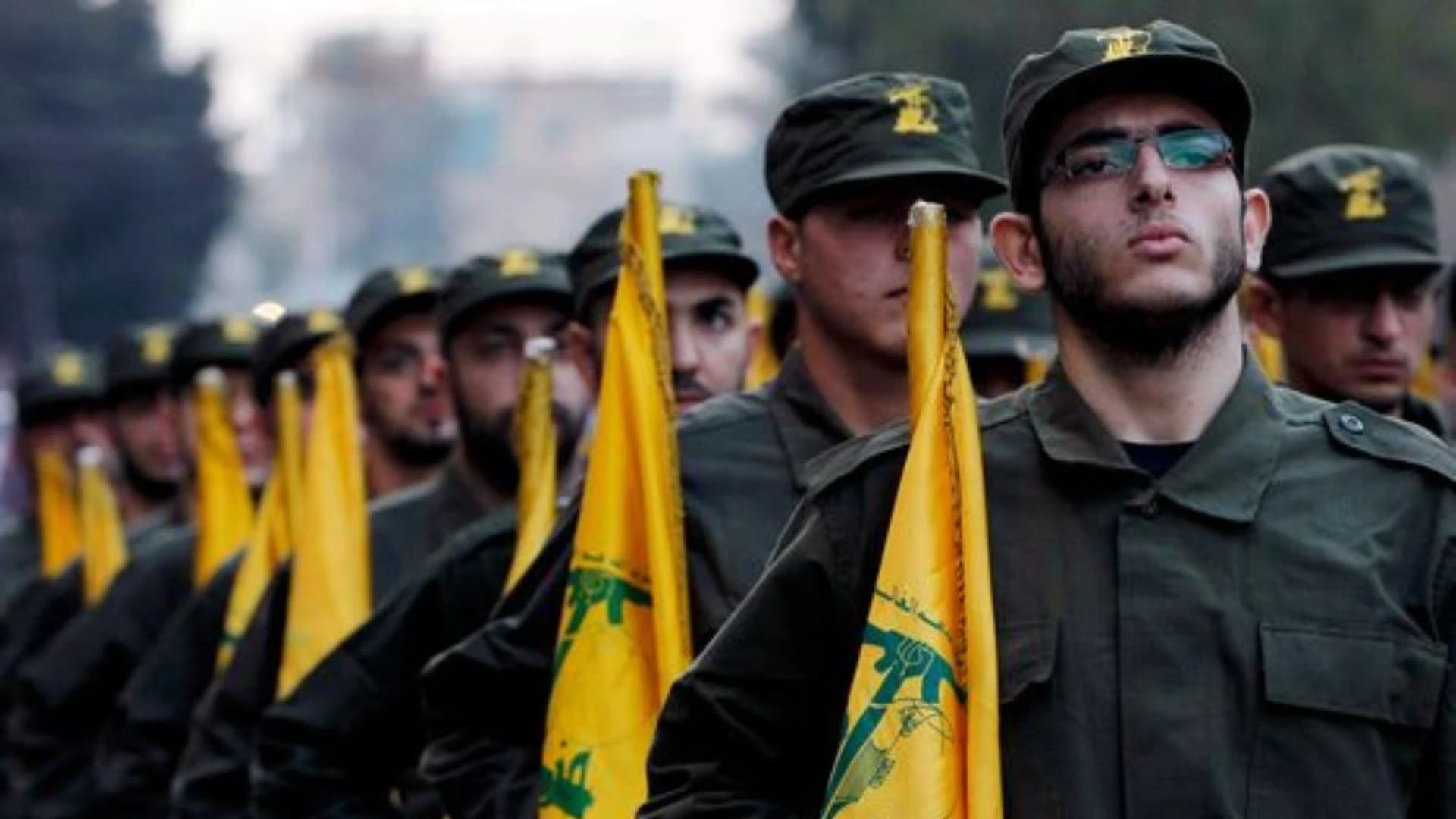 Terroristas do Hezbollah carregam bandeiras da facção