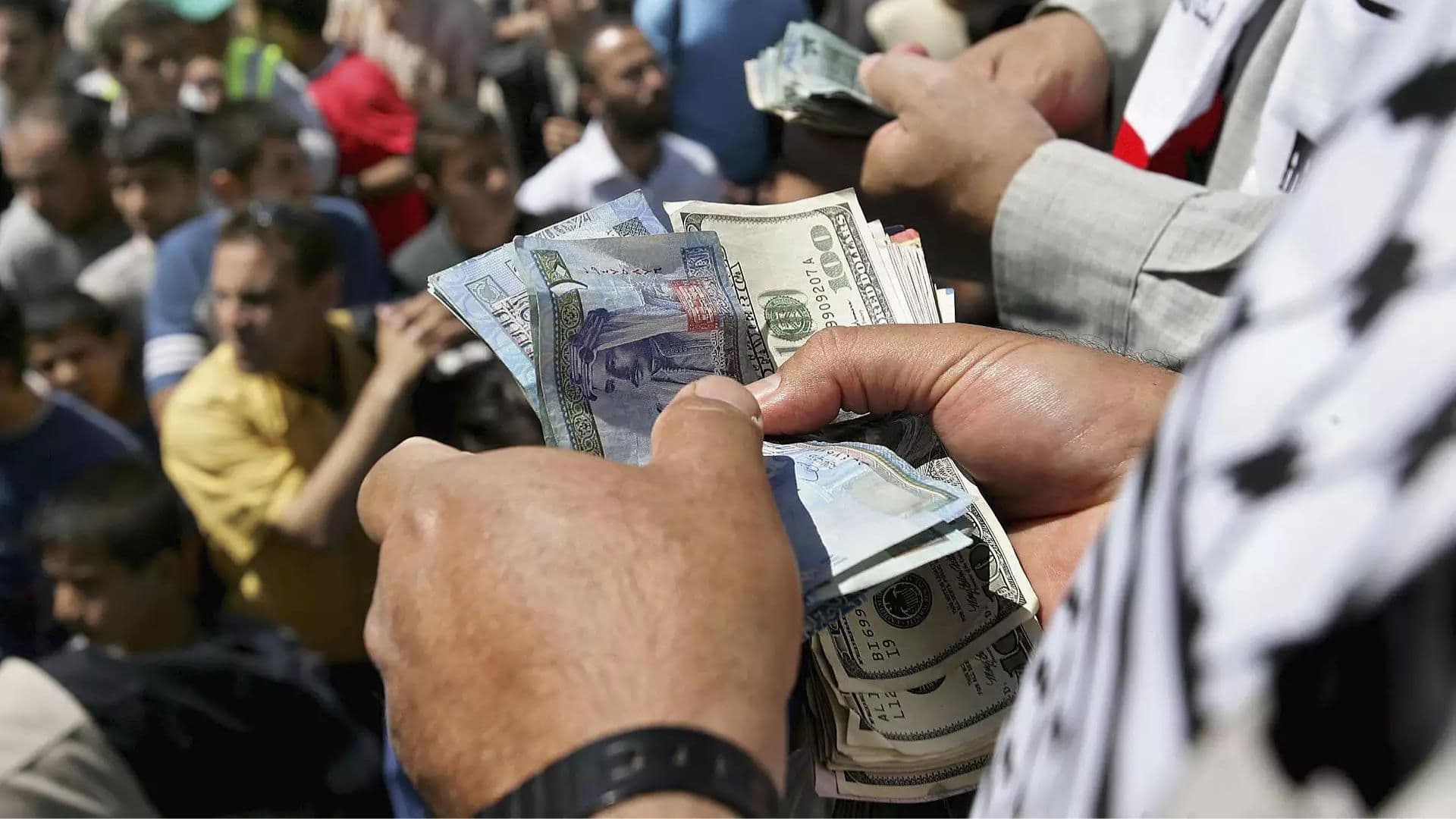Palestino segurando maço de dinheiro.