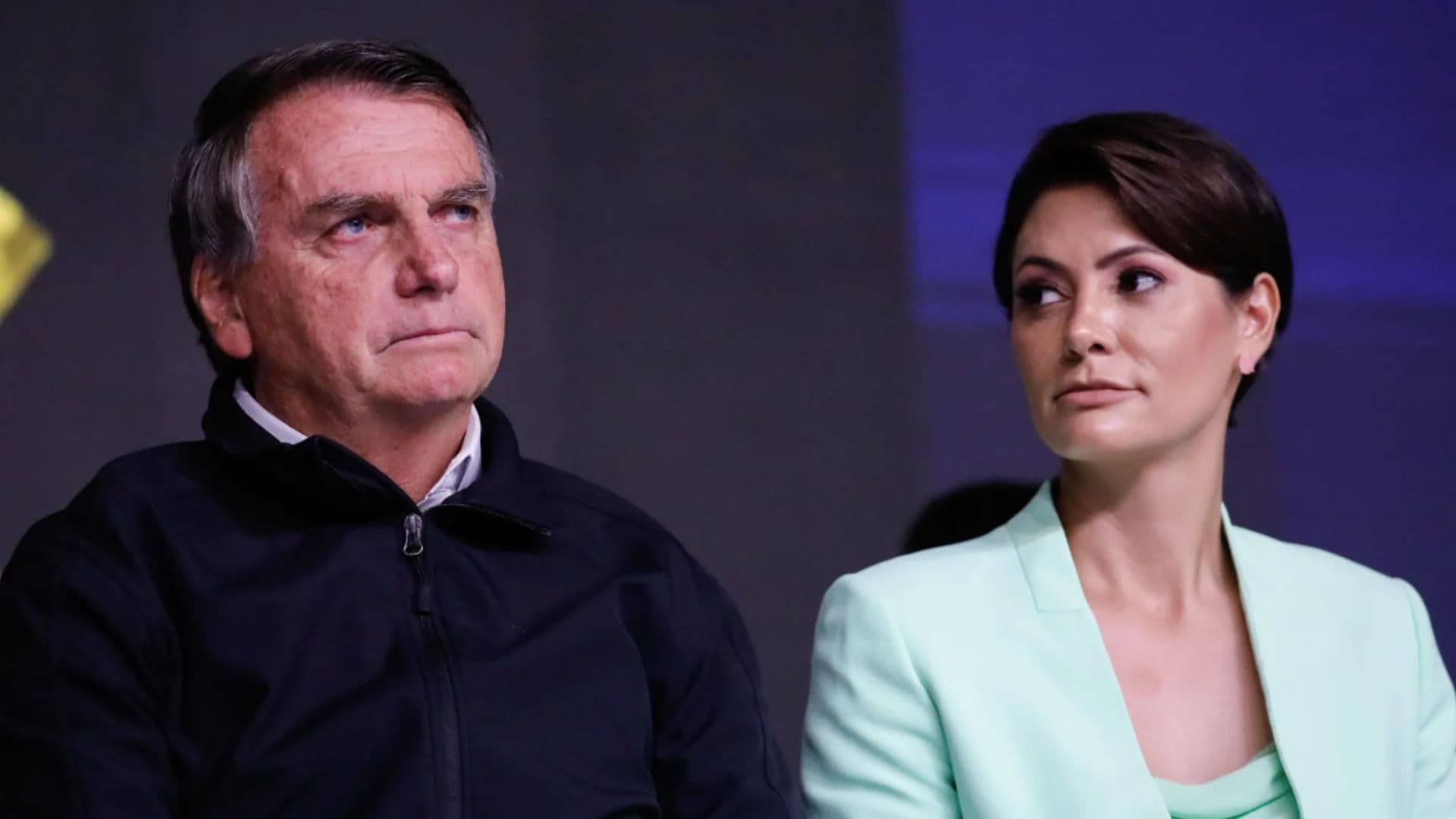 Jair Bolsonaro pediu que Moraes seja retirado de processos sobre golpe de Estado. Na foto ele aparece sério ao lado da esposa, Michelle Bolsonaro.