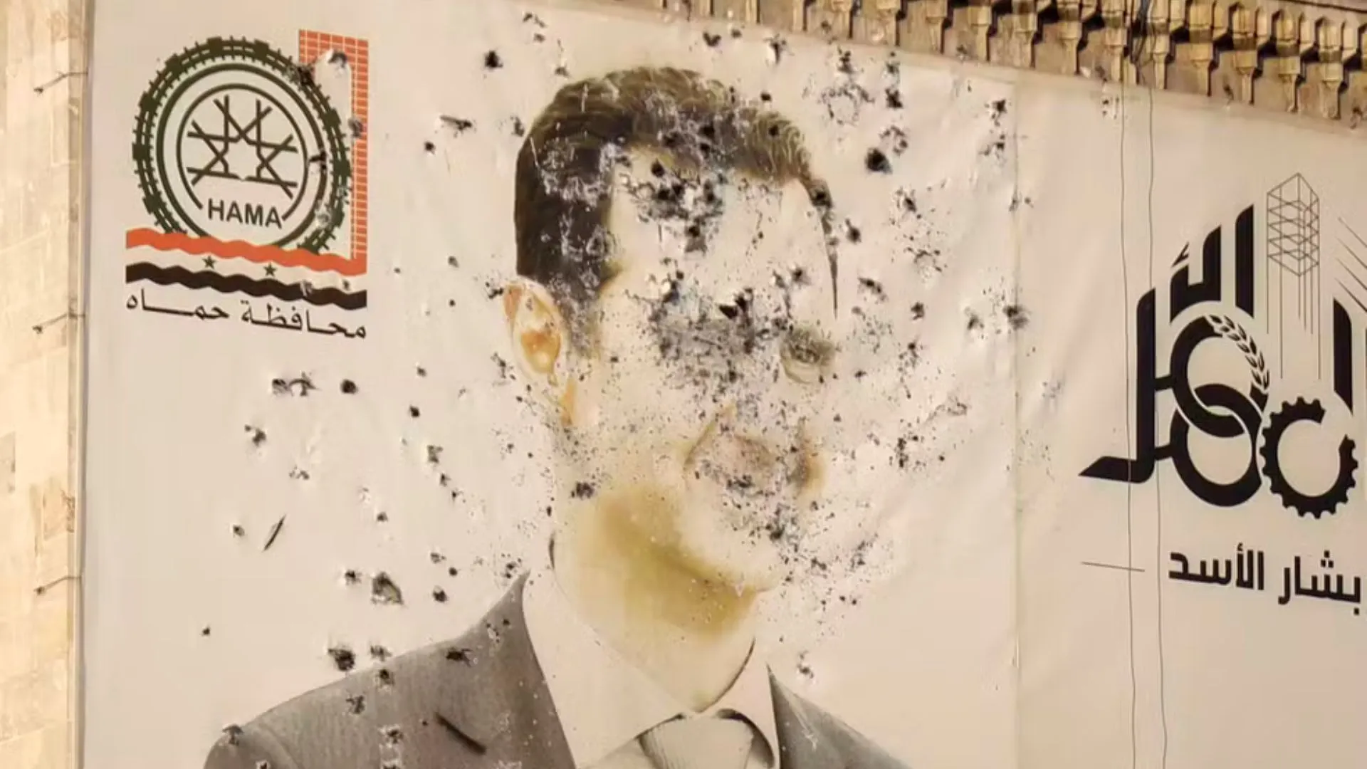 Poster de Bashar al-Assad atingido pelos tiros de rebeldes após a conquista da cidade de Hama.