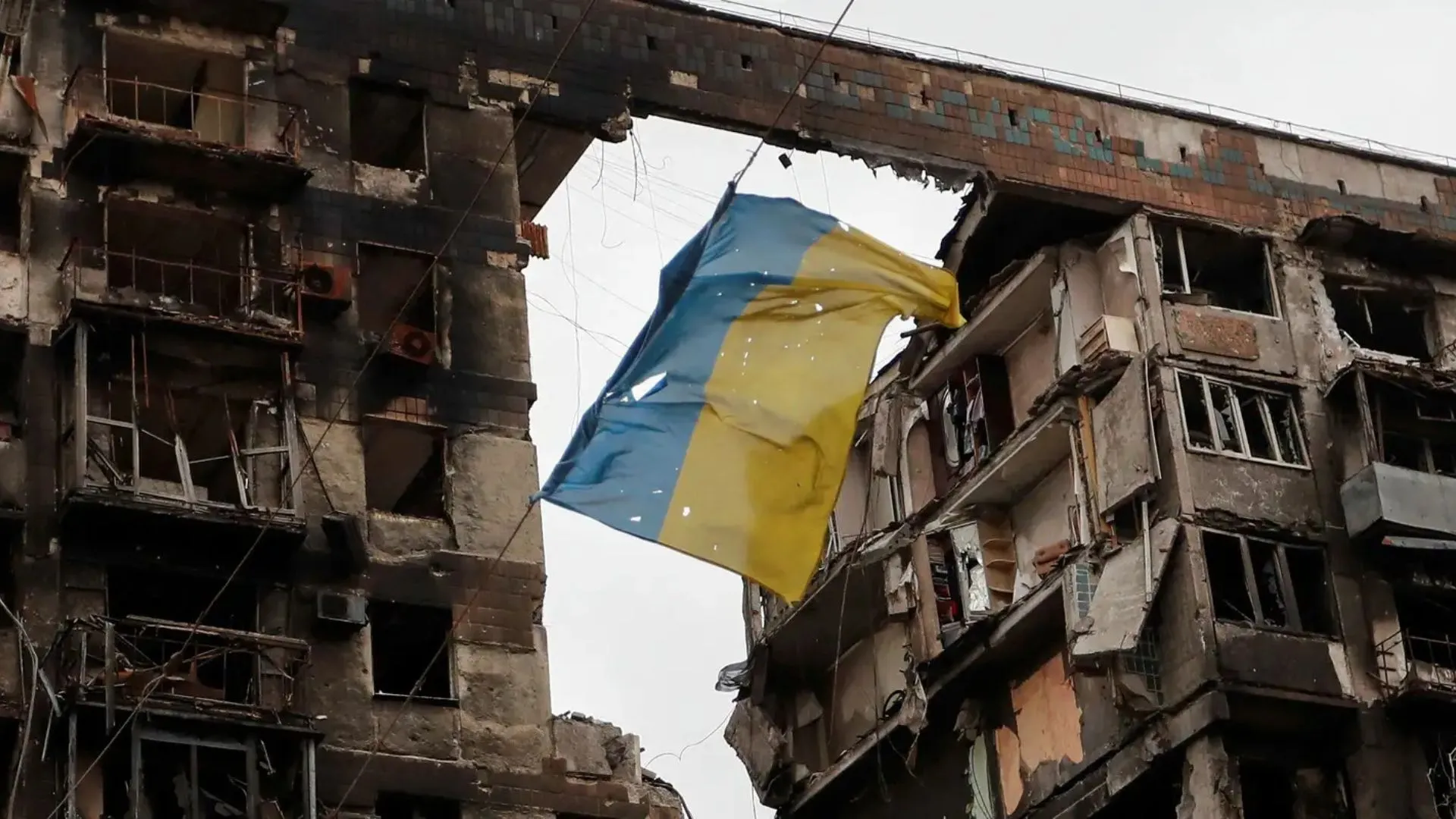 Bandeira ucraniana rasgada pendurada em meio aos escombros da guerra contra a Rússia.