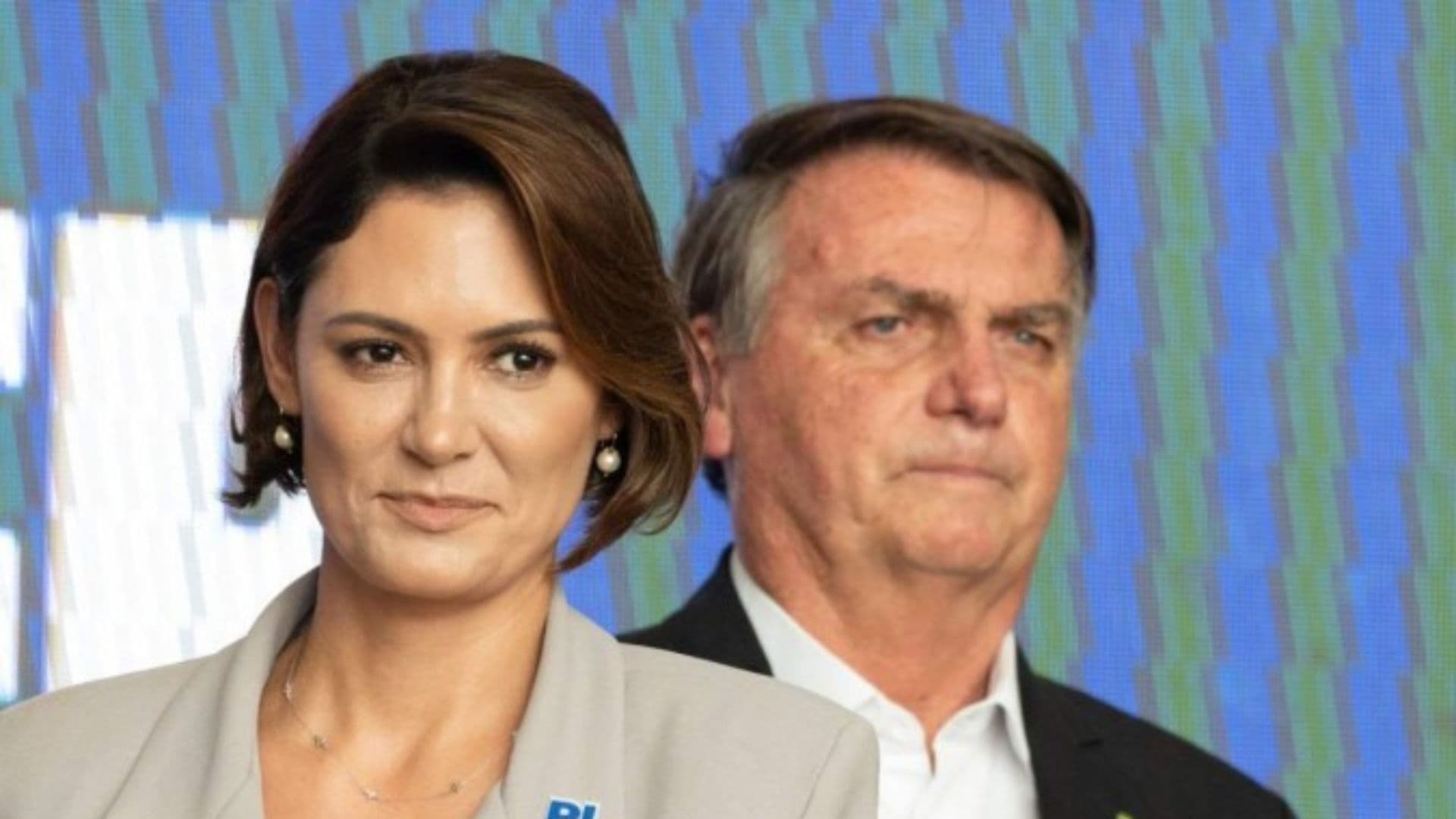 Michelle Bolsonaro em frente a Bolsonaro.