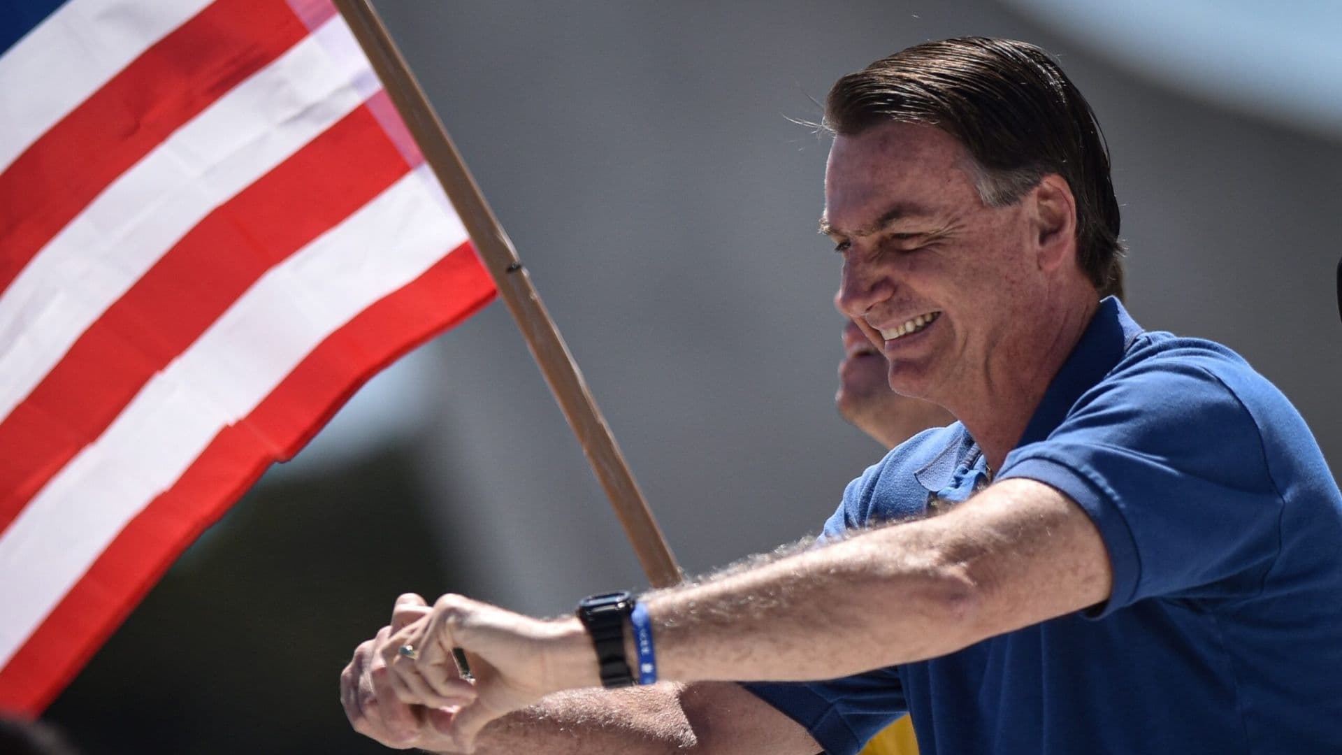 Jair Bolsonaro perto de bandeira americana durante viagem oficial