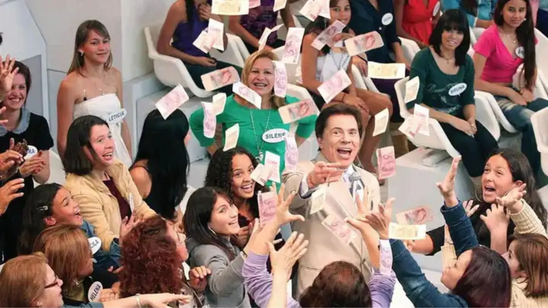 Silvio Santos jogando notas de R$5 durante programa.