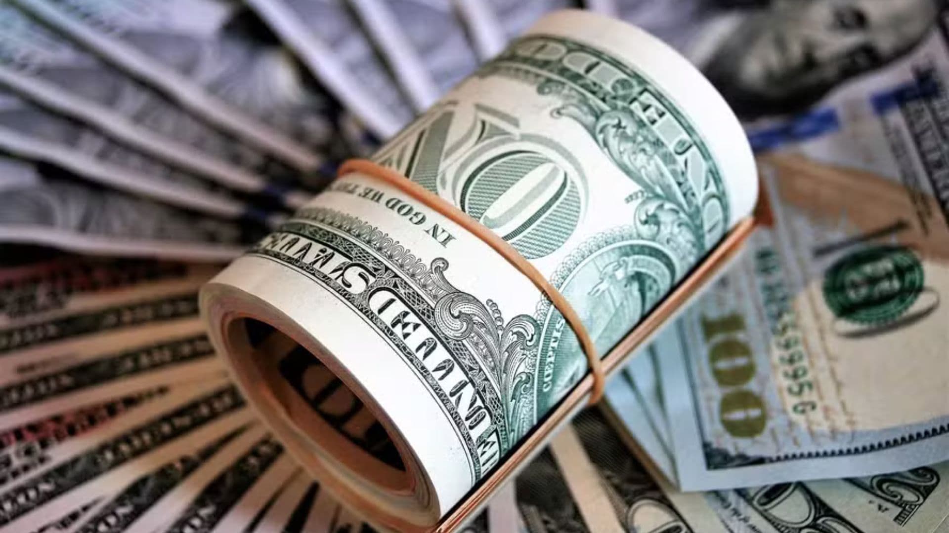 maço de dólar em cima de um monte de notas.
