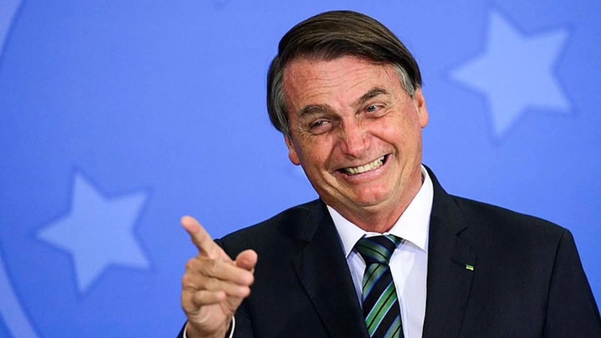 Bolsonaro sorrindo e apontando