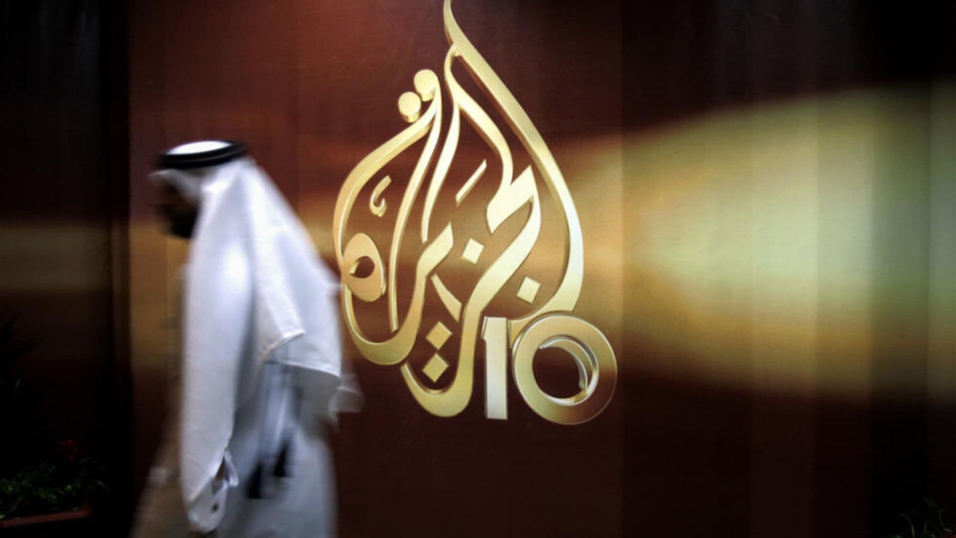 Arabe em frente ao símbolo da Al-Jazeera.