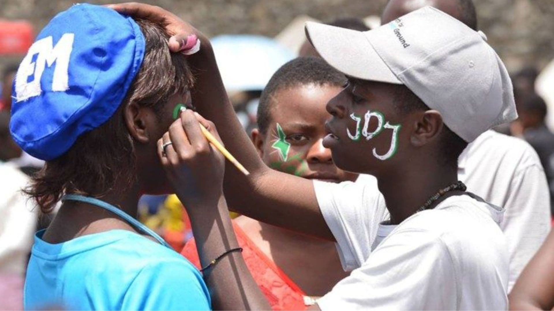 Jovens cristãos pintam seus rostos no Congo.