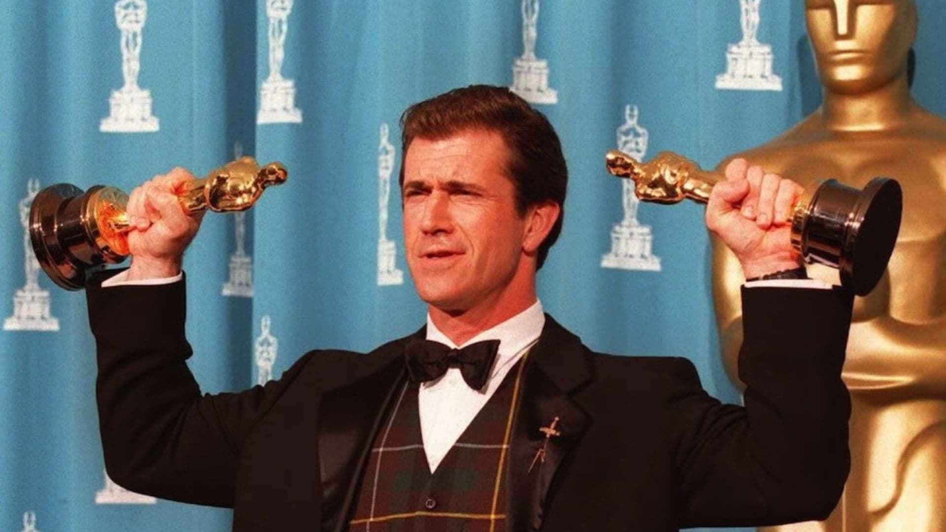 Mel Gibson segurando duas estatuetas do Oscar. Ator fez críticas à premiação.