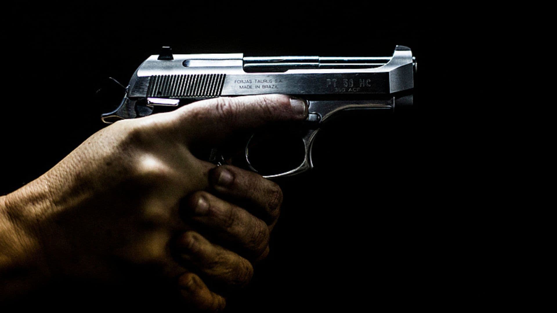 Uma mão segurando uma pistola.