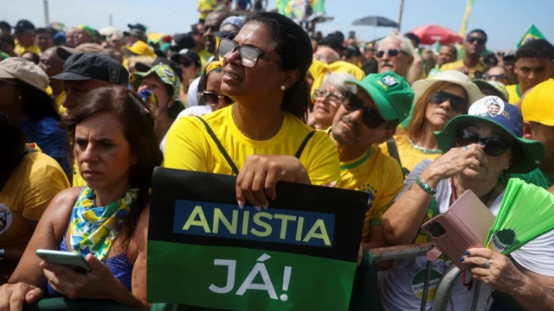 Mulher segurando um cartaz dizendo "Anistia Já" durante o protesto em Copacabana.