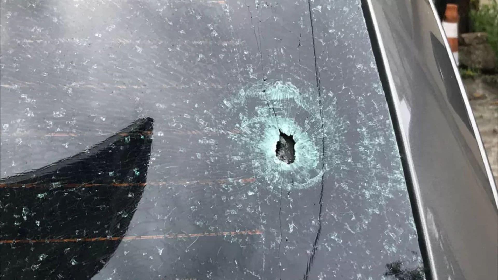Imagem de um carro atingido por um disparo.