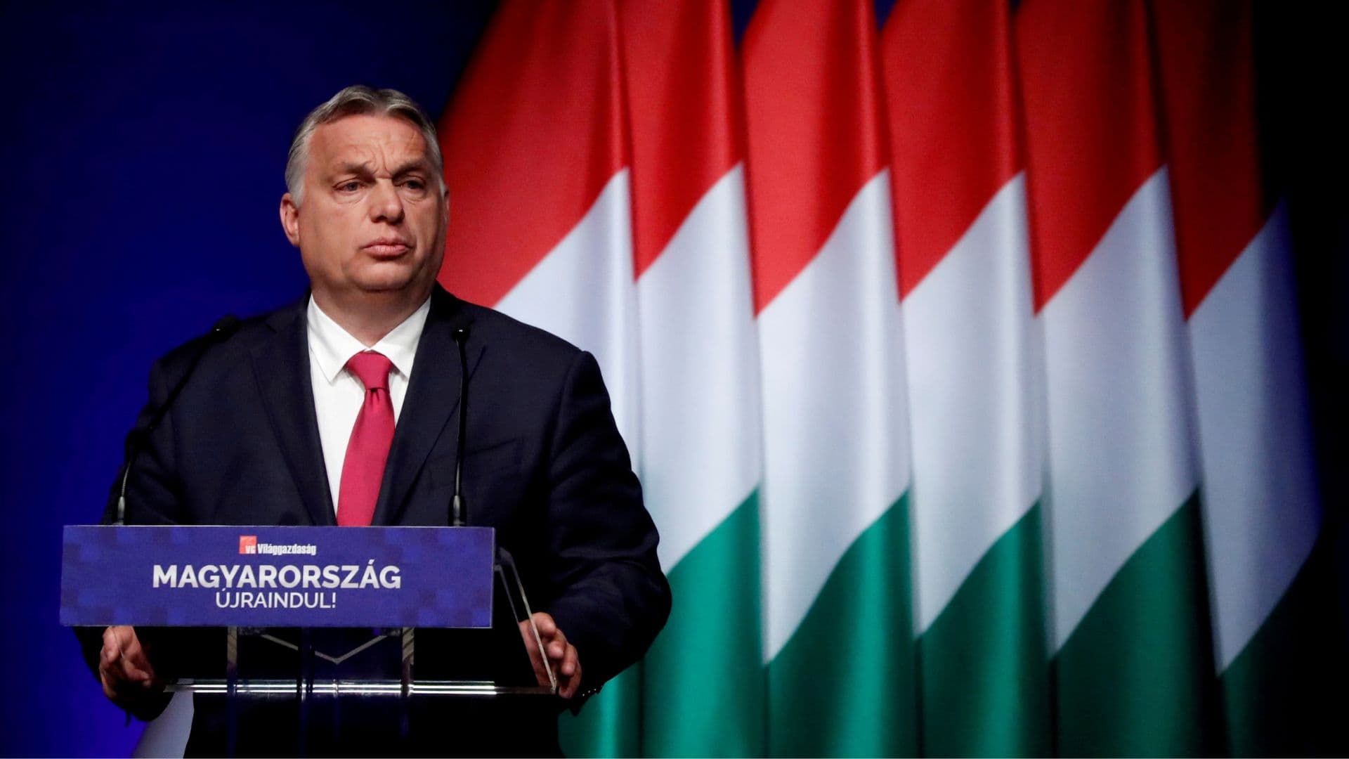 Primeiro-ministo da Hungria, Viktor Orbán em frente a bandeiras de seu país.