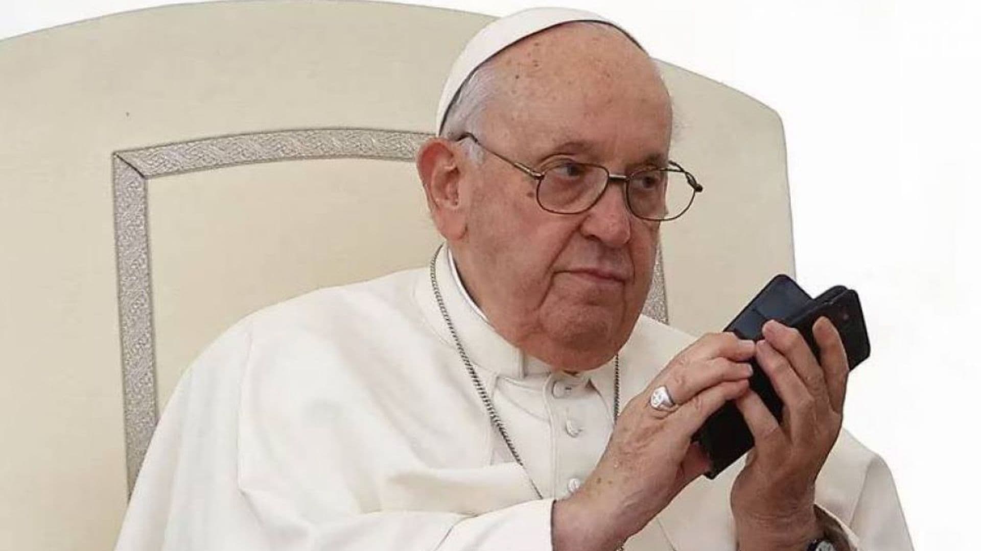 Papa francisco segurando telefones celulares.