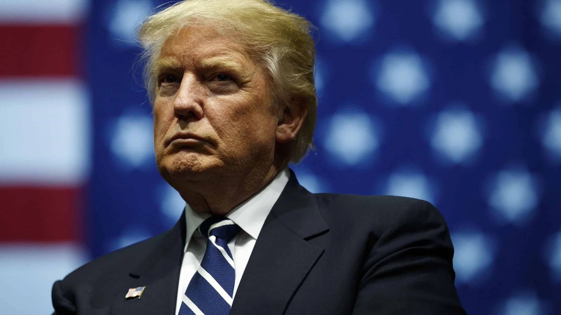 Donald Trump em frente a bandeira dos Estados Unidos da América