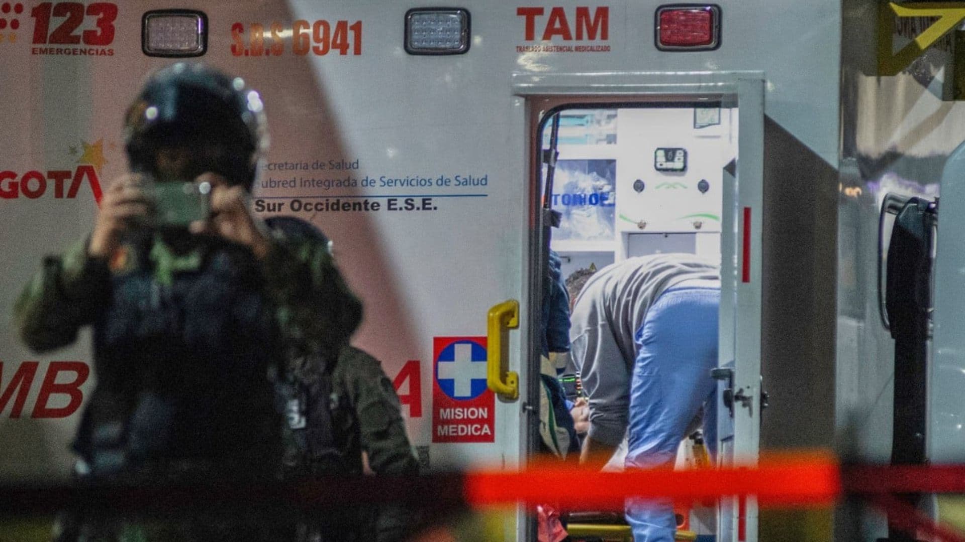 Uribe sendo levado para uma ambulância.