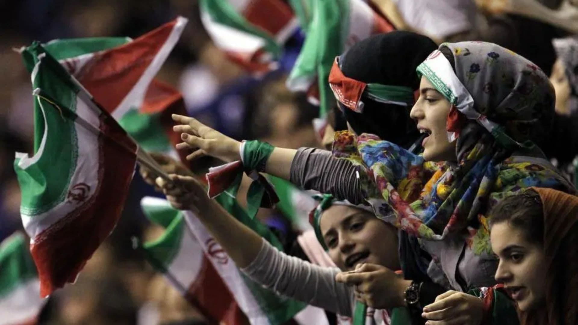 Mulheres iranianas segurando bandeiras do país, lá elas sofrem com repressão.