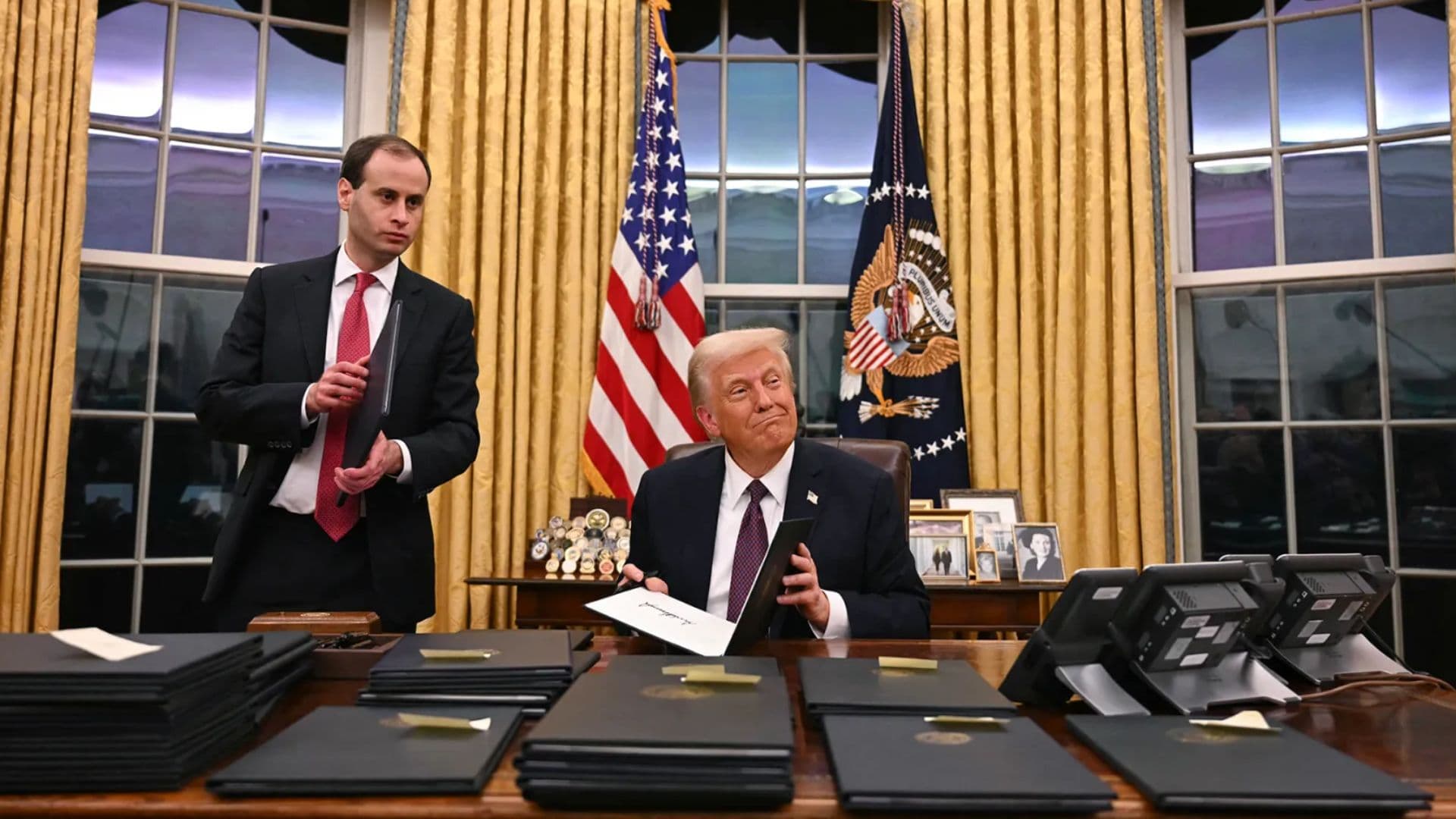 O presidente Donald Trump assinando ordens executivas no Salão Oval em 20 de janeiro.