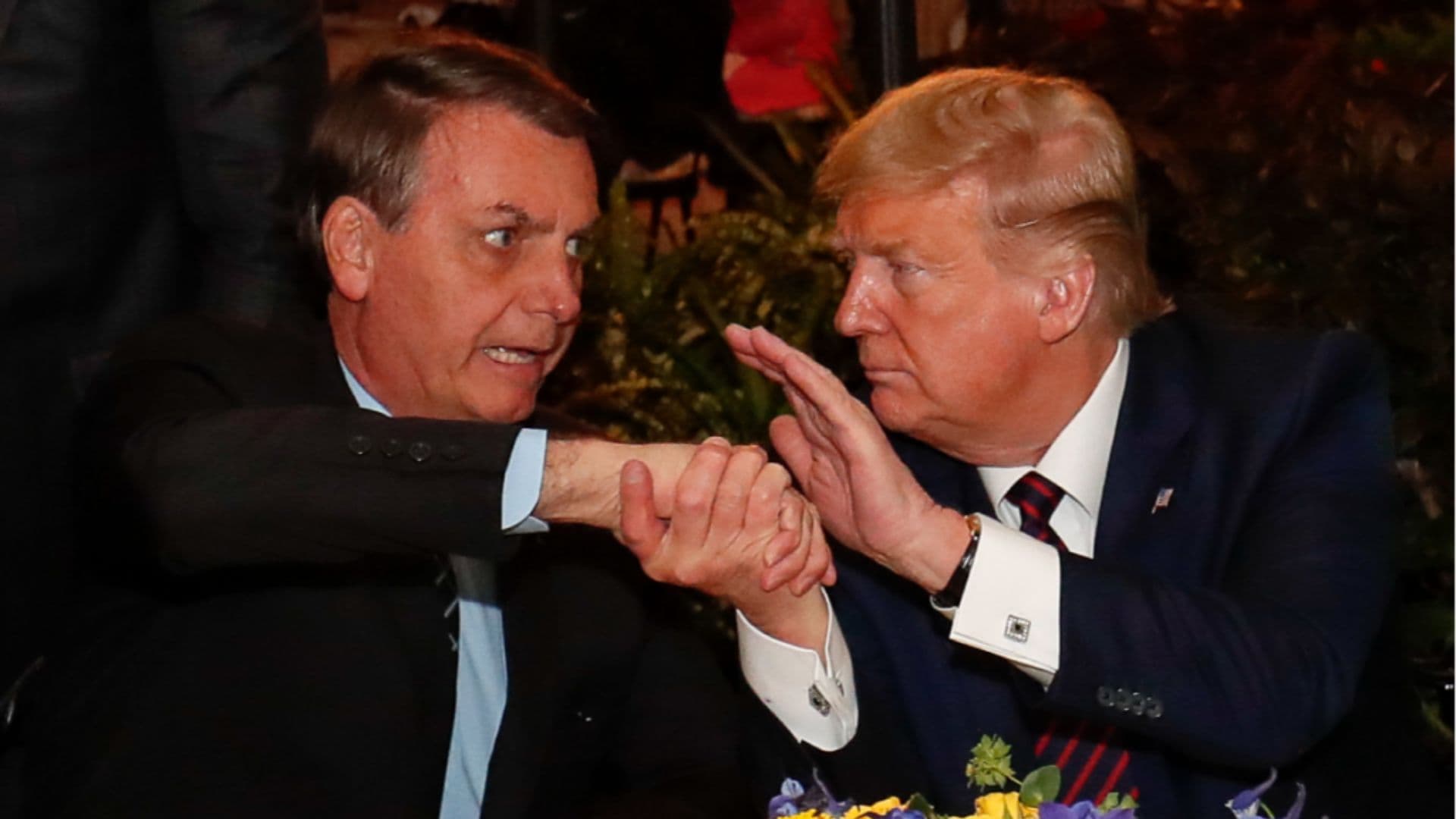 Bolsonaro apertando a mão de Trump.