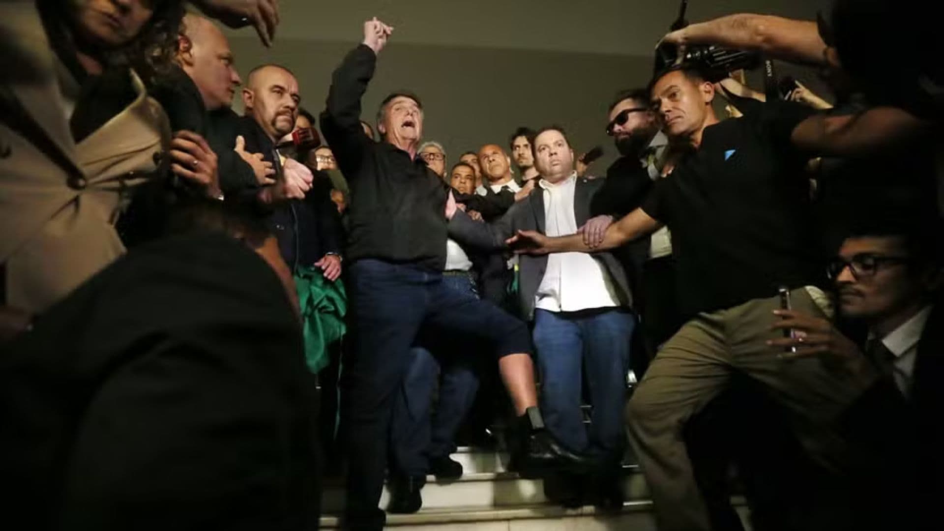 Bolsonaro mostra tornozeleira eletrônica na saída do Congresso Nacional.