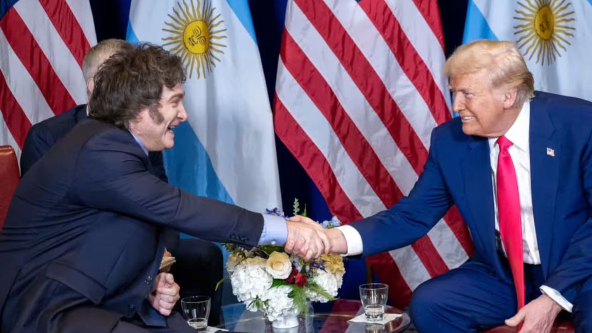 Milei e Trump apertando mãos, países podem fazer acordo sobre vistos.