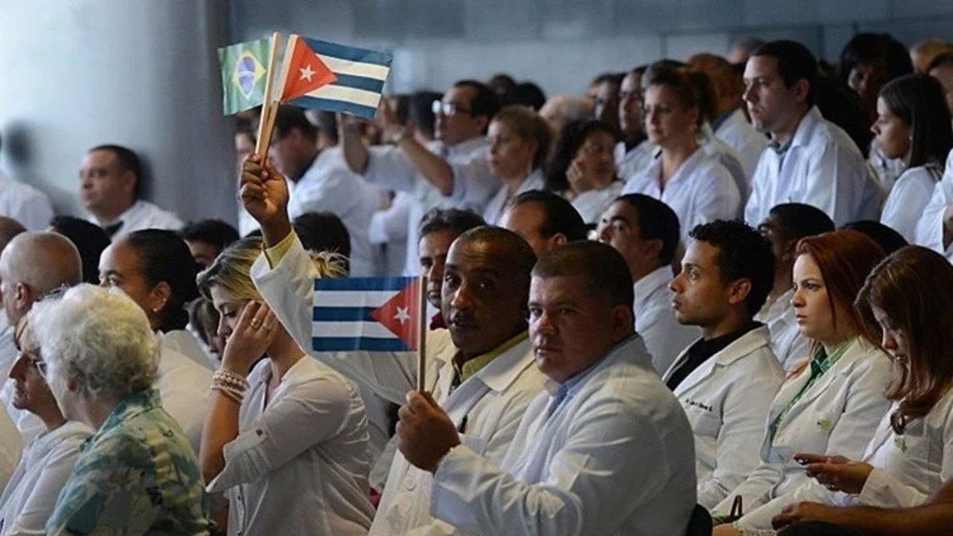 Médicos cubanso segurando bandeira do país.