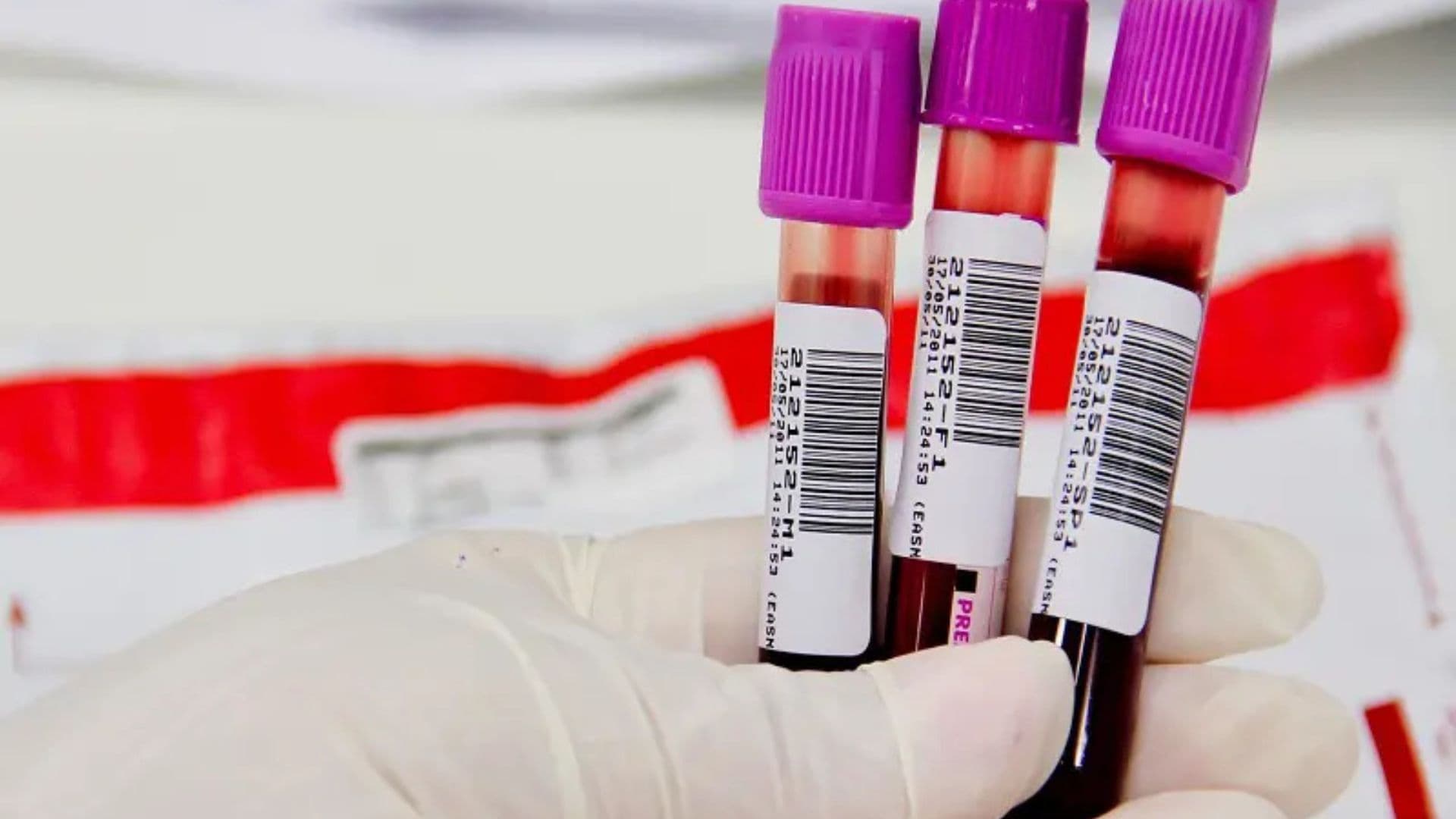 Médico manipulando frascos com sangue.