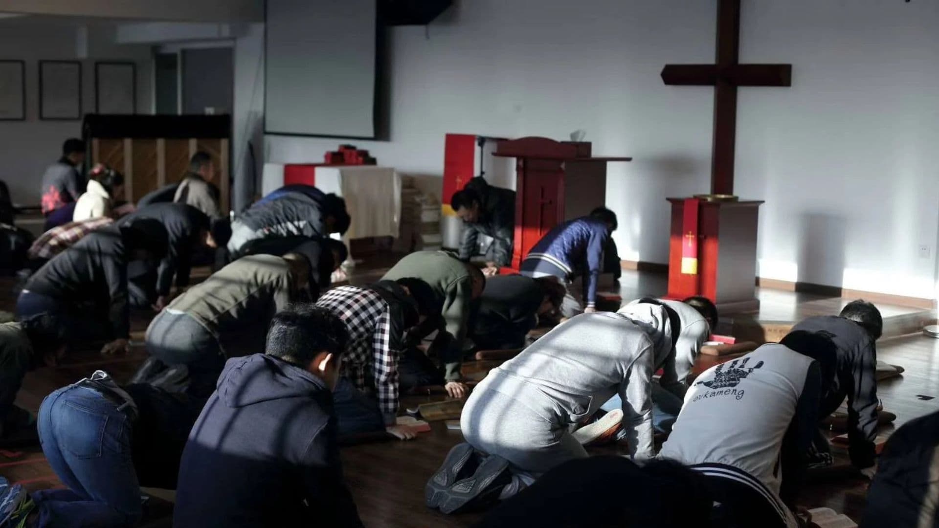 Cristãos ajoelhados durante missa em igreja clandestina