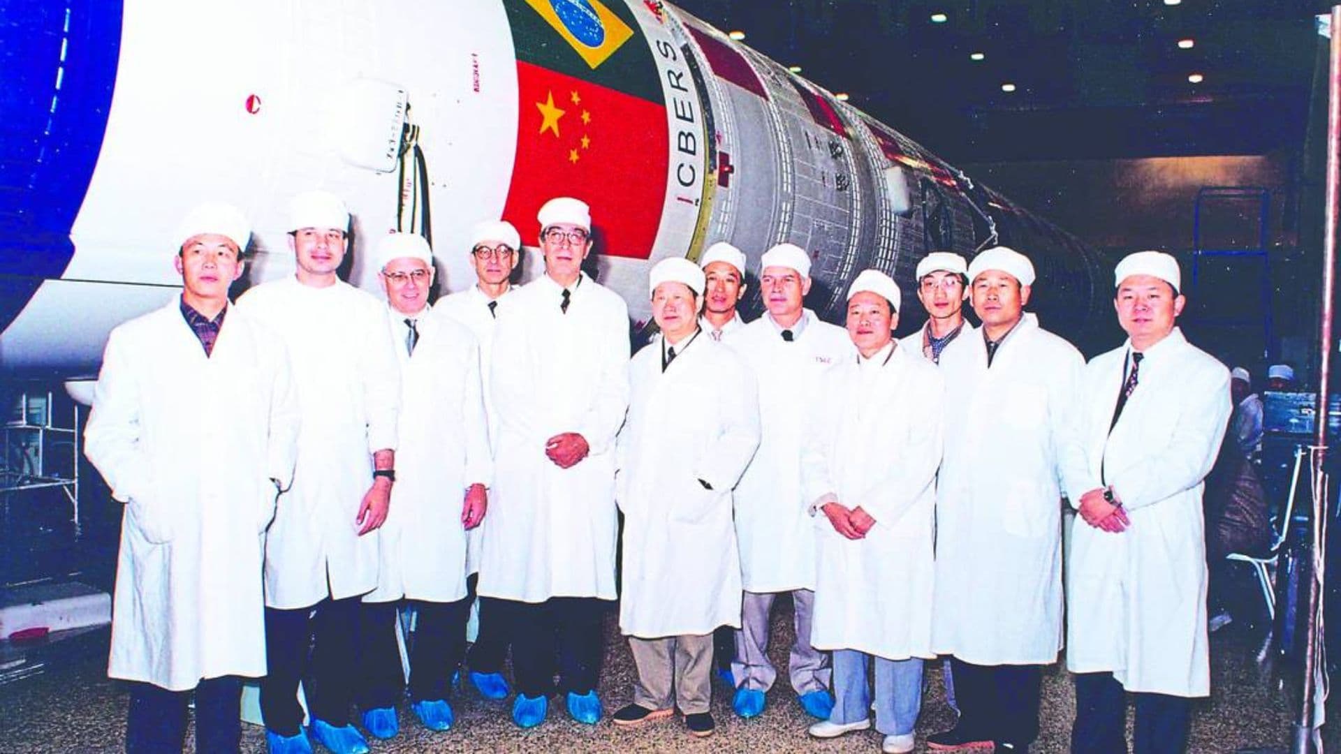 Cientistas chineses ao lado de satelite criado em parceria com o Brasil