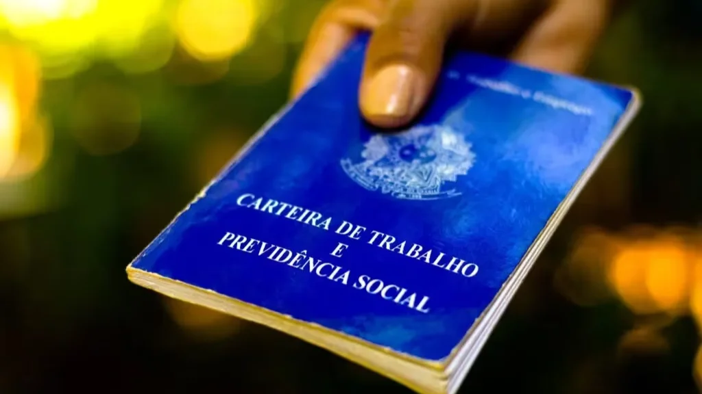 Mão segurando uma carteira de trabalho