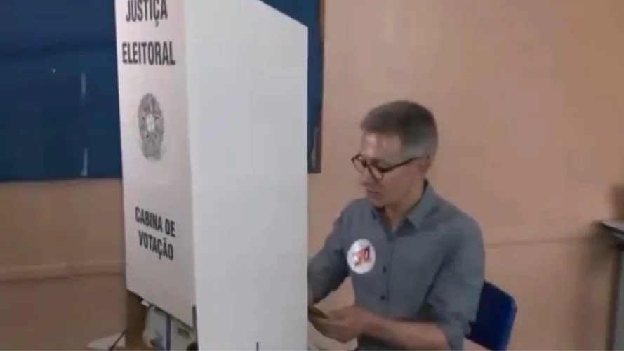 Romeu Zema usa celular enquanto vota